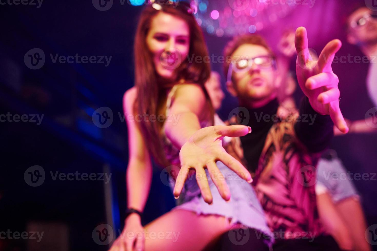 actief paar dansen en poseren. jong mensen is hebben pret in nacht club met kleurrijk laser lichten foto