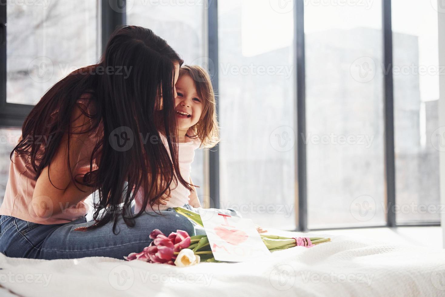 omarmen elk ander. dochter feliciteert moeder met vakantie en geeft boeket van bloemen foto