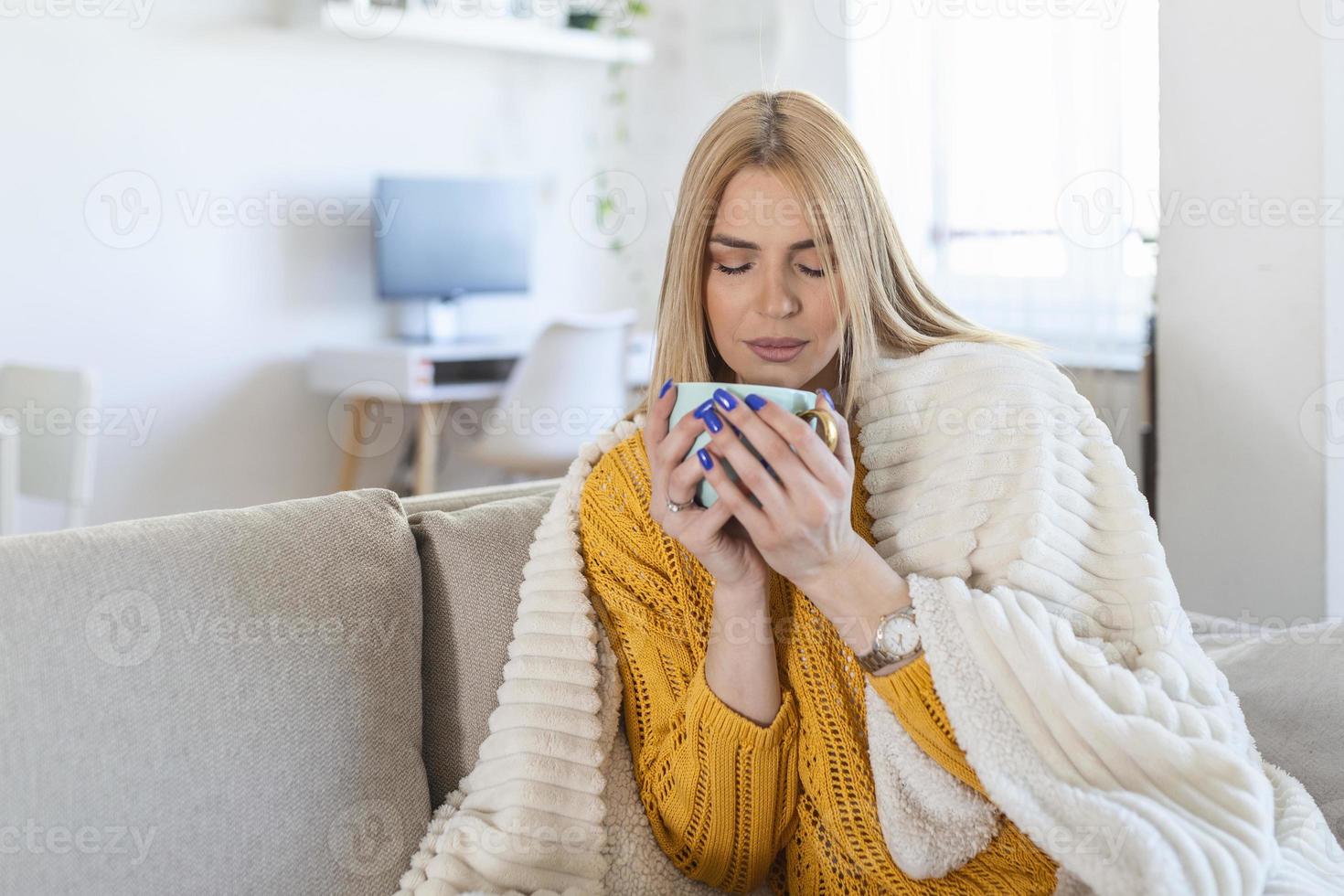 mooi elegant vrouw zittend Bij huis denken, romantisch melancholie stemming, vervelend gebreid trui, gevoel warm, winter stijl, drinken koffie, gedekt in wollen deken foto