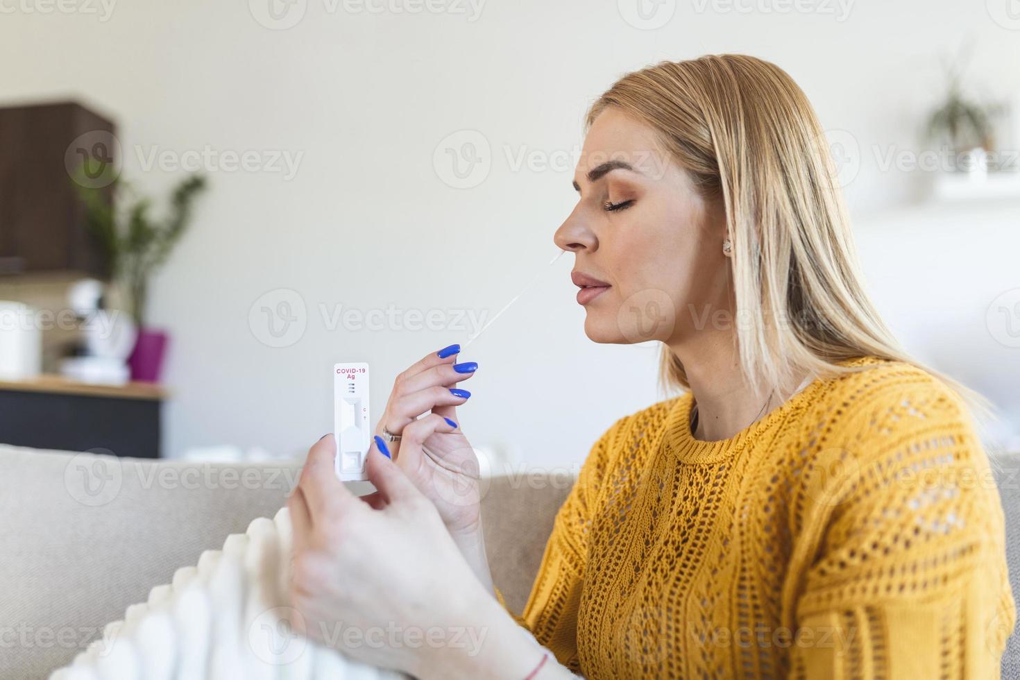 jong vrouw Holding zelf testen zelf beheerd wattenstaafje en medisch buis voor coronavirus covid19, voordat wezen zelf getest Bij huis foto