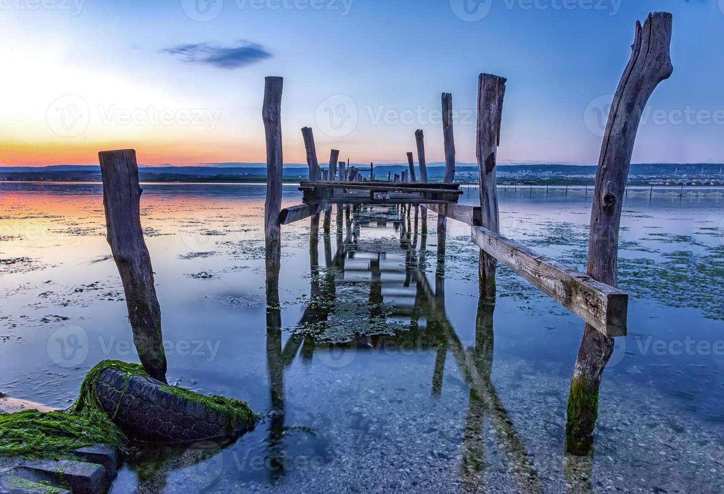 oud gebroken houten pier in blauw uur foto