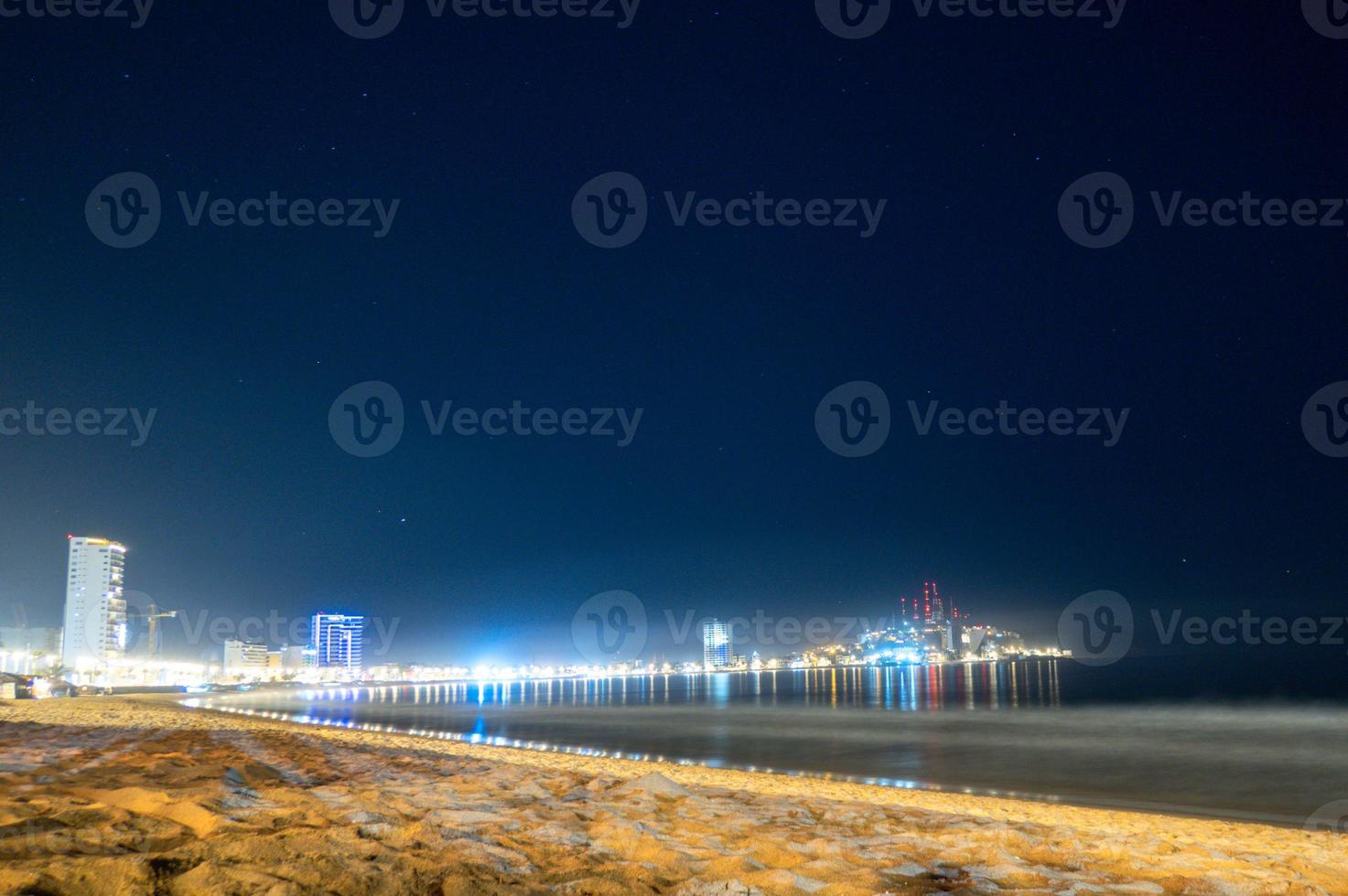 mazatlan sinaloa strand Bij nacht met lichtgevend stad in de achtergrond foto