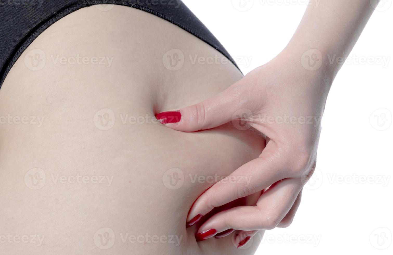 Bij vrouw knijpen haar dik Aan haar kont, geïsoleerd Aan wit achtergrond. foto