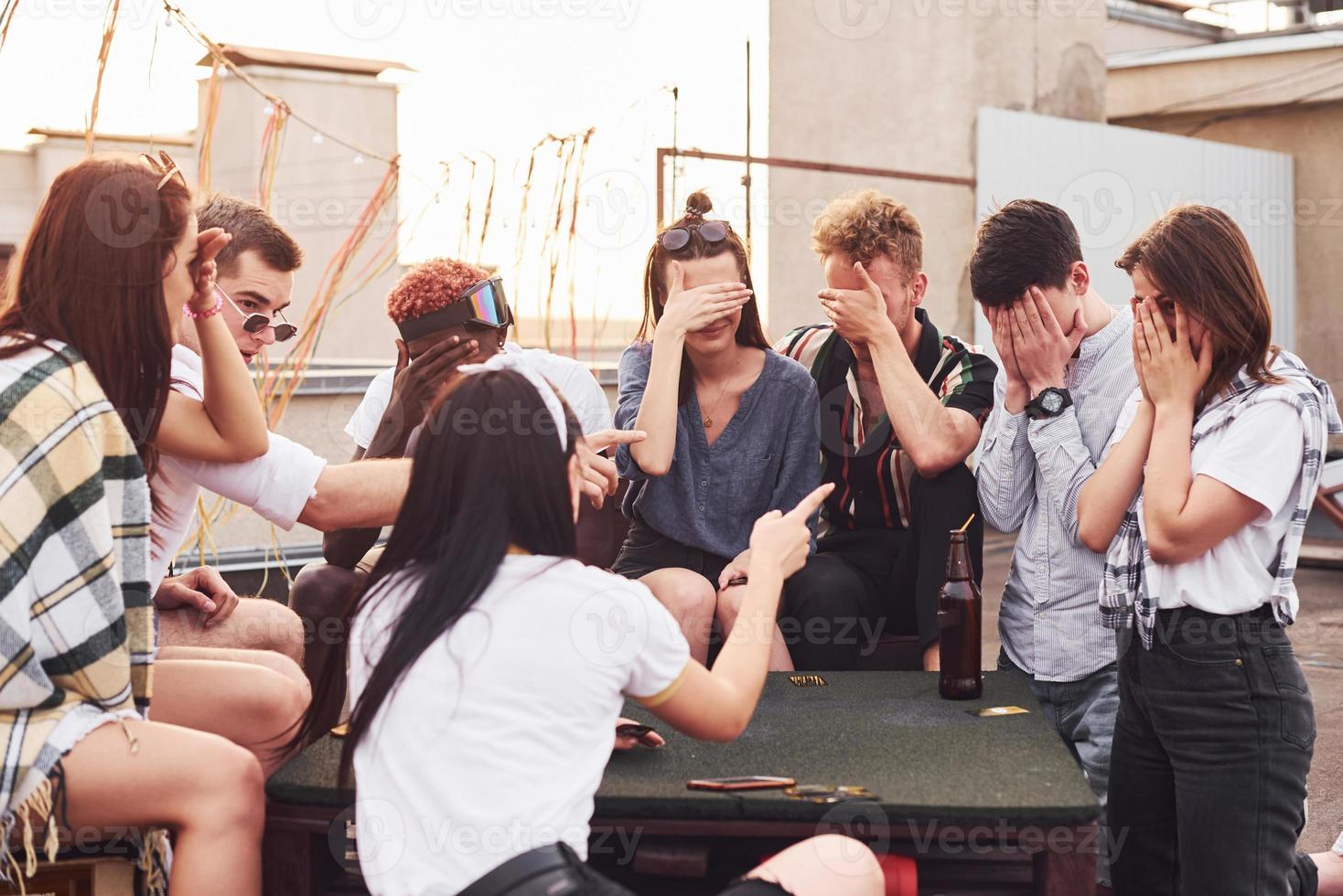 spelen spel. groep van jong mensen in gewoontjes kleren hebben een partij Bij op het dak samen Bij dag foto