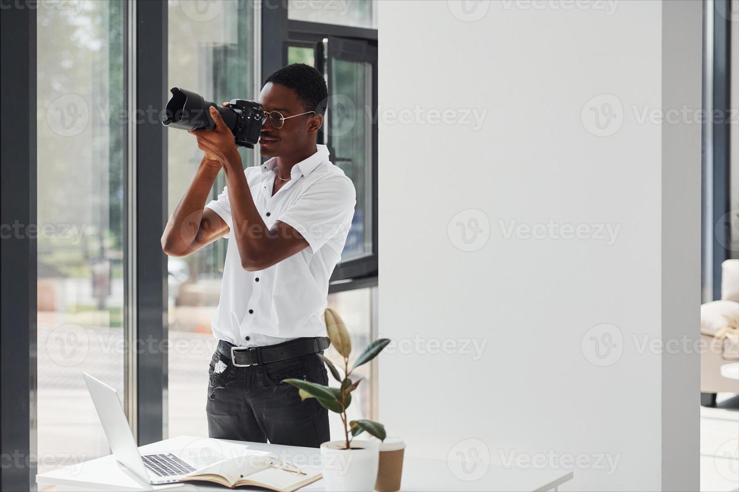 testen camera. jong Afrikaanse Amerikaans Mens in formeel kleren is in de kantoor foto