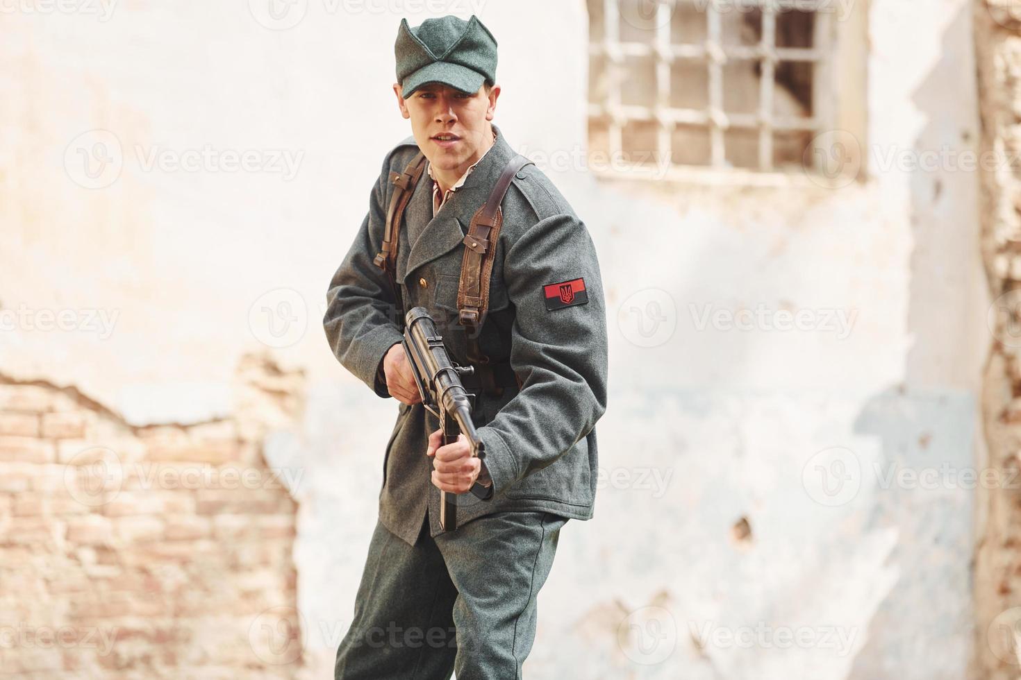 ternopil, Oekraïne - juni 2020 upa oekraïens opstandeling leger film filmen. afbeeldingen van achter de schermen. jong soldaat met wapen in de buurt oud gebouw foto