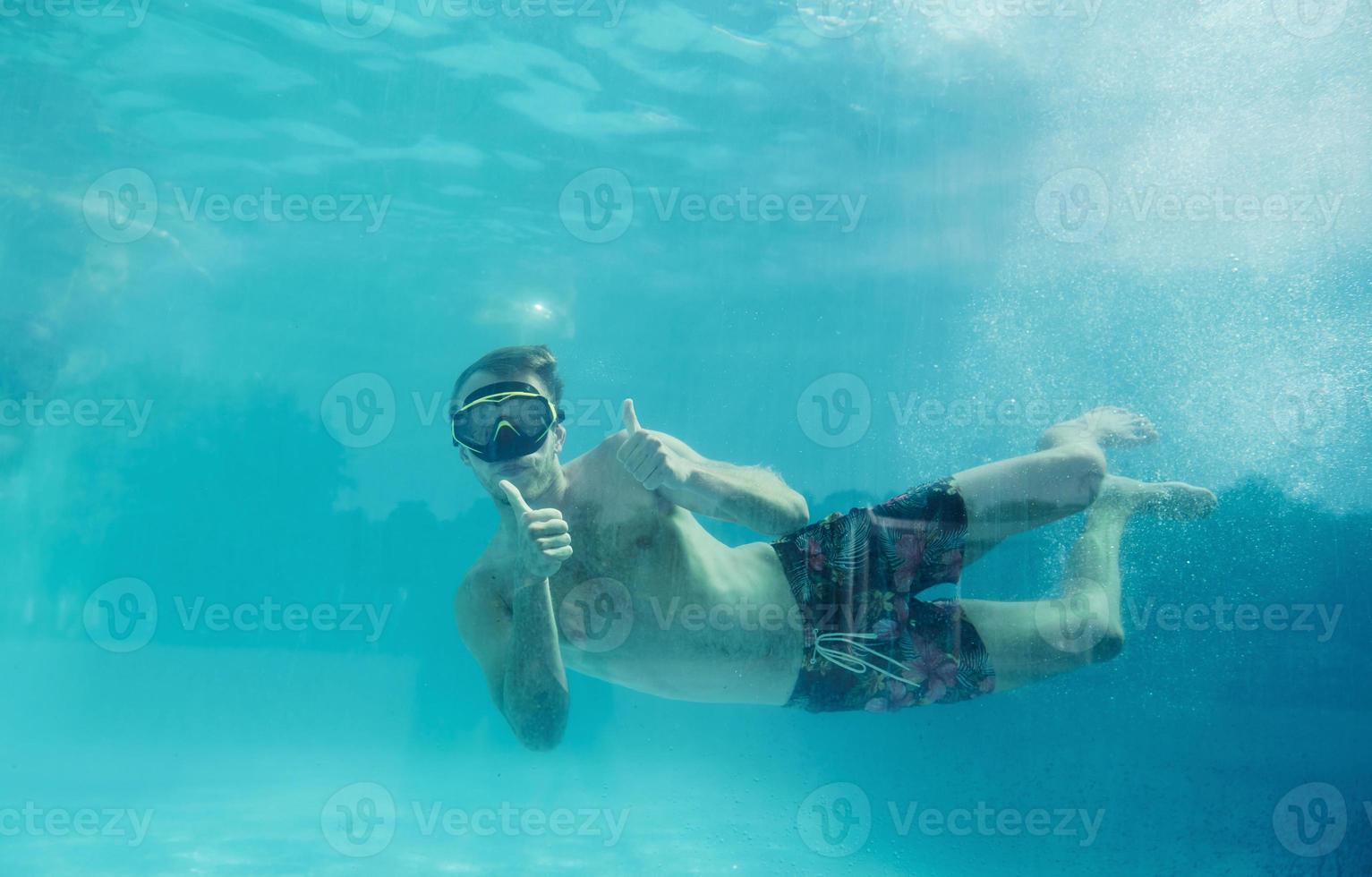 Mens zwemmen onderwater- in de zwembad Bij dag. hebben pret foto