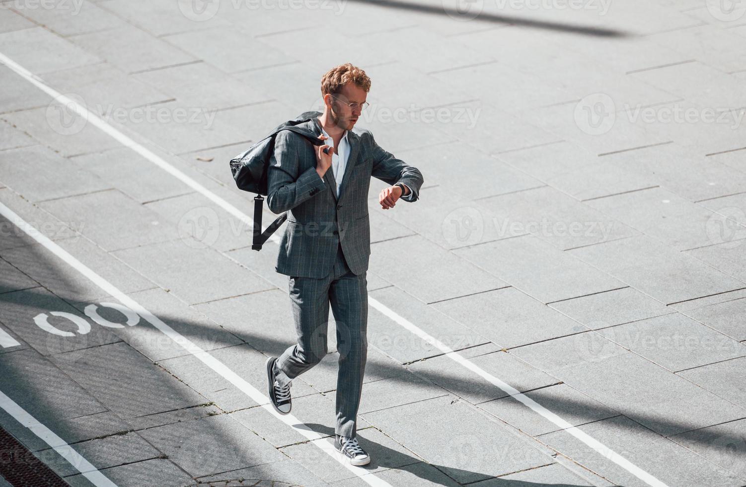 wandelingen Aan de weg. jong zakenman in grijs formeel slijtage is buitenshuis in de stad foto