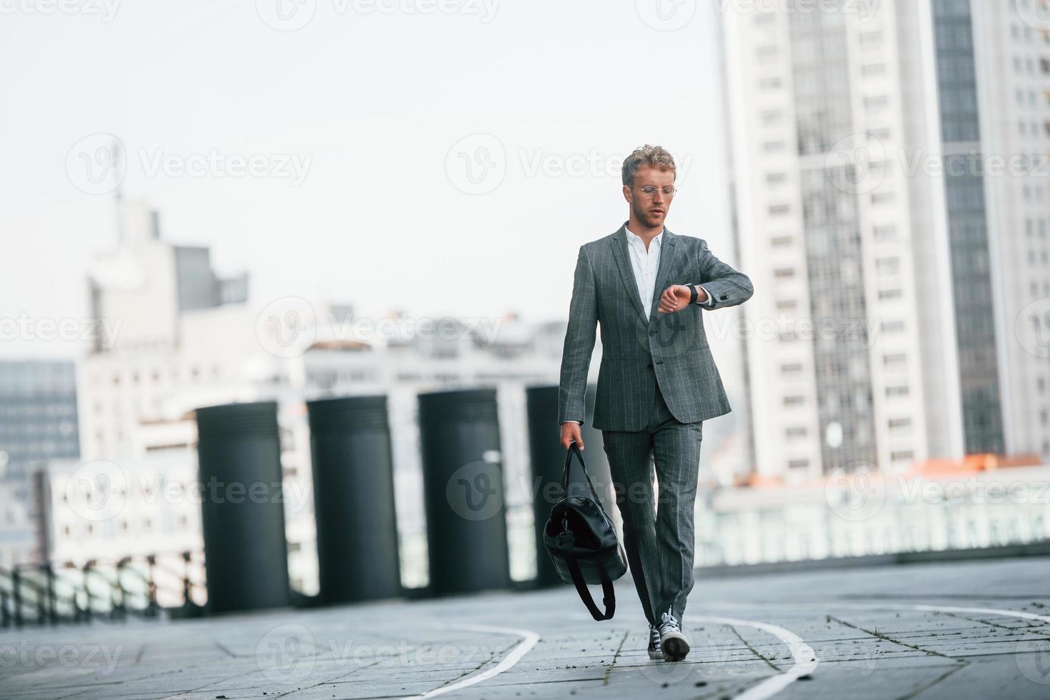 wandelingen Aan de weg. jong zakenman in grijs formeel slijtage is buitenshuis in de stad foto