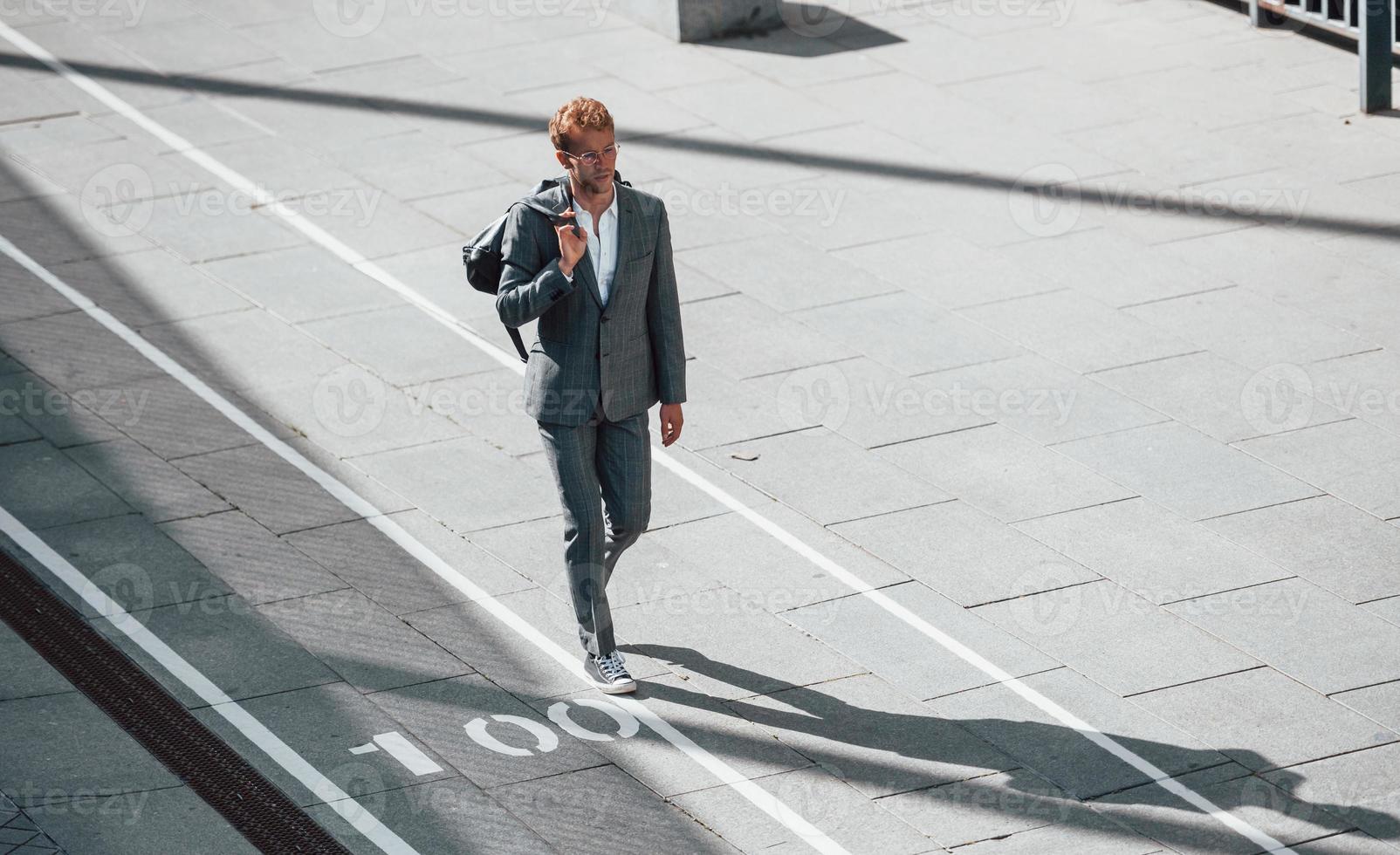 wandelingen Aan de weg. jong zakenman in grijs formeel slijtage is buitenshuis in de stad foto
