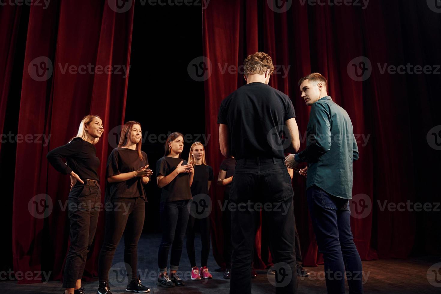 groep van acteurs in donker gekleurde kleren Aan repetitie in de theater foto