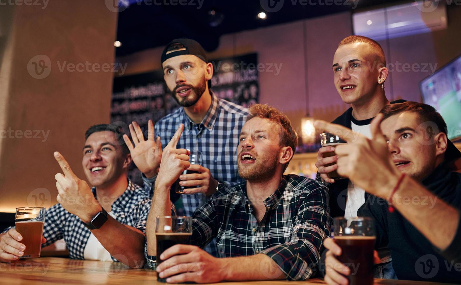 Amerikaans voetbal fans aan het kijken TV. groep van mensen samen binnenshuis in de kroeg hebben pret Bij weekend tijd foto