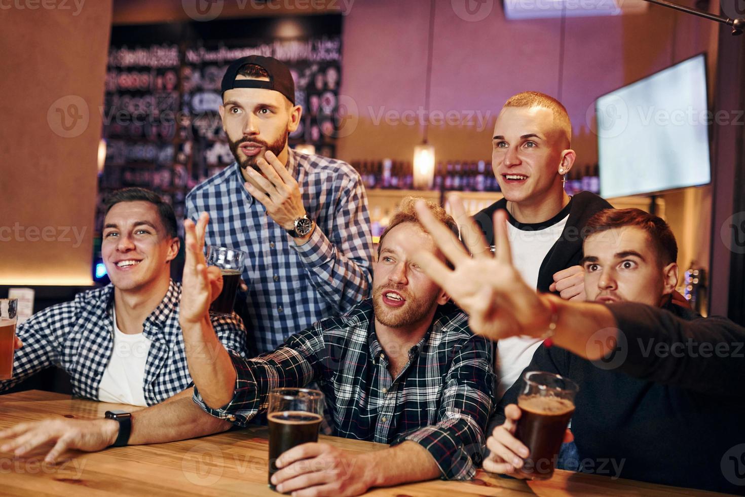 Amerikaans voetbal fans aan het kijken TV. groep van mensen samen binnenshuis in de kroeg hebben pret Bij weekend tijd foto