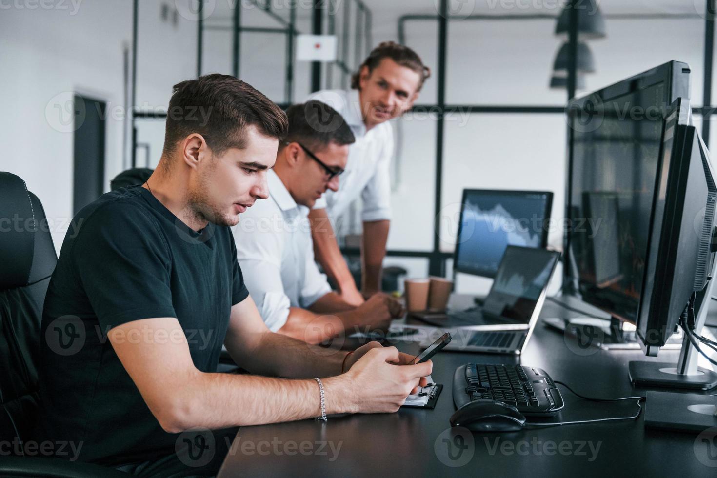 team van effectenmakelaars werken in modern kantoor met veel Scherm schermen foto