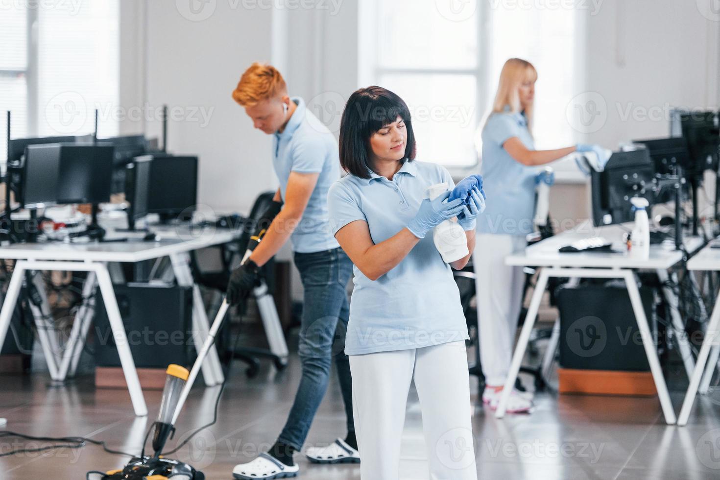 reinigt vloer. groep van arbeiders schoon modern kantoor samen Bij dag foto