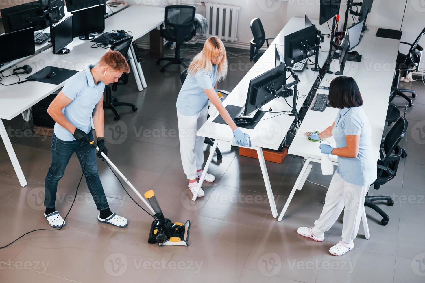 reinigt vloer. groep van arbeiders schoon modern kantoor samen Bij dag foto