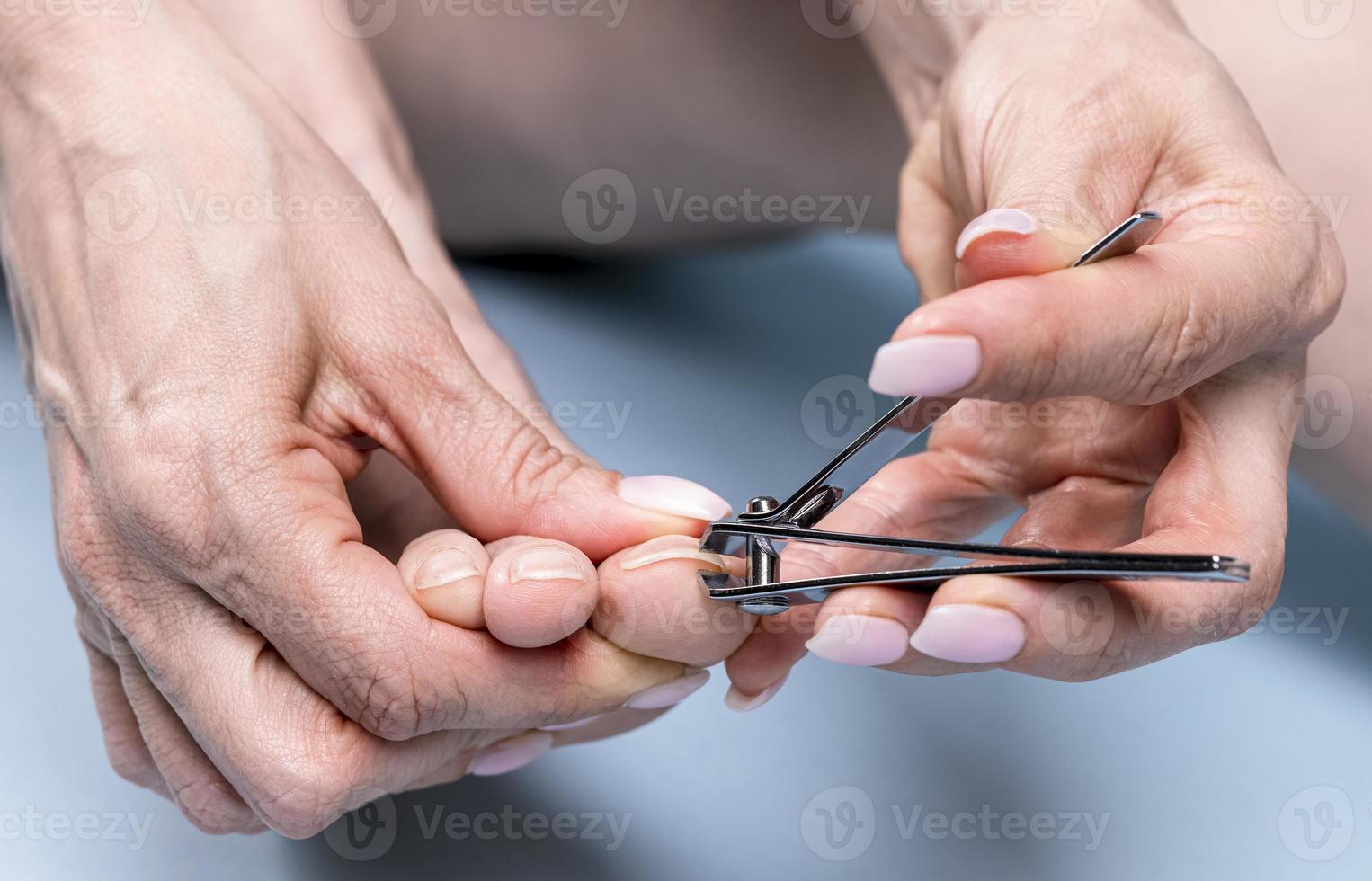teen nagels snijdend met nagel tondeuses, pedicure concept foto