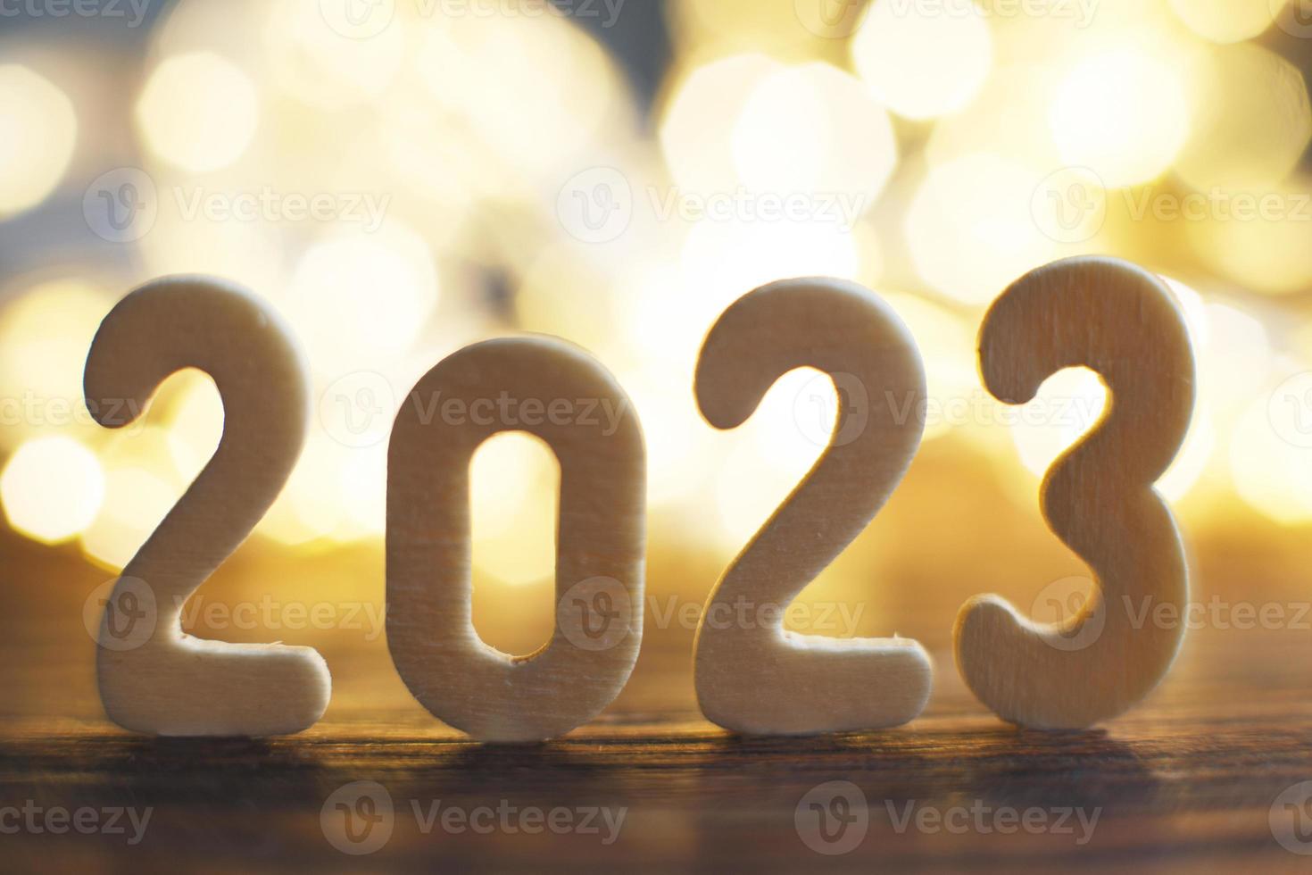 houten aantal 2023 op Kerstmis prachtig glimmend goud achtergrond. fonkeling feestelijk wazig bokeh foto