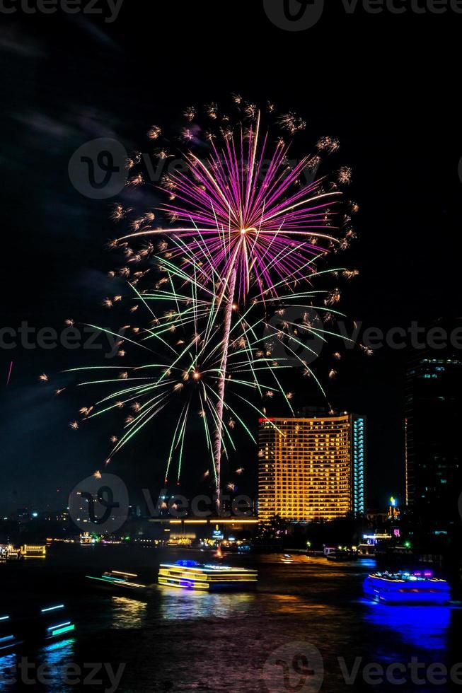 vuurwerk op de rivier in de donkere lucht foto