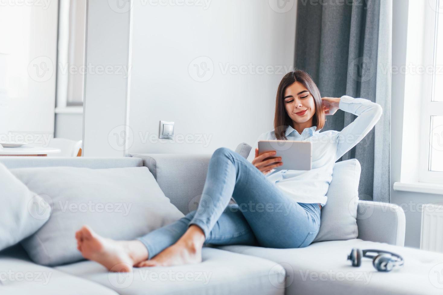 jong vrouw is binnenshuis in kamer van modern huis Bij dag foto