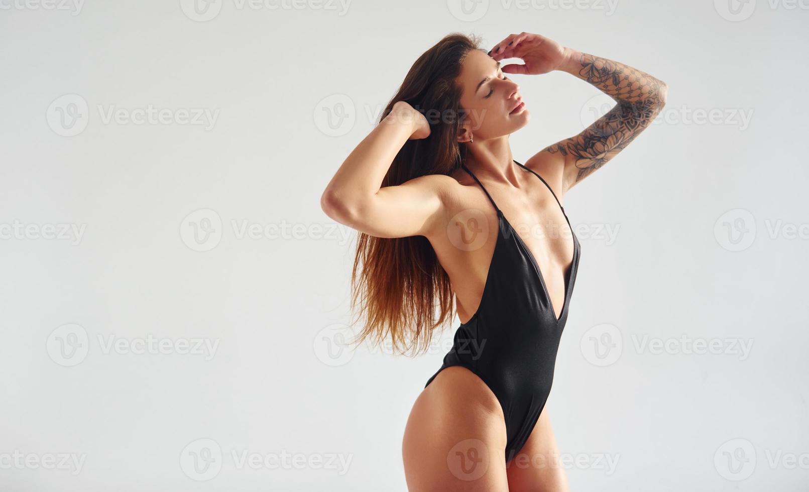 staand en poseren. mooi verleidelijk sportief vrouw met sexy lichaam is in de studio foto