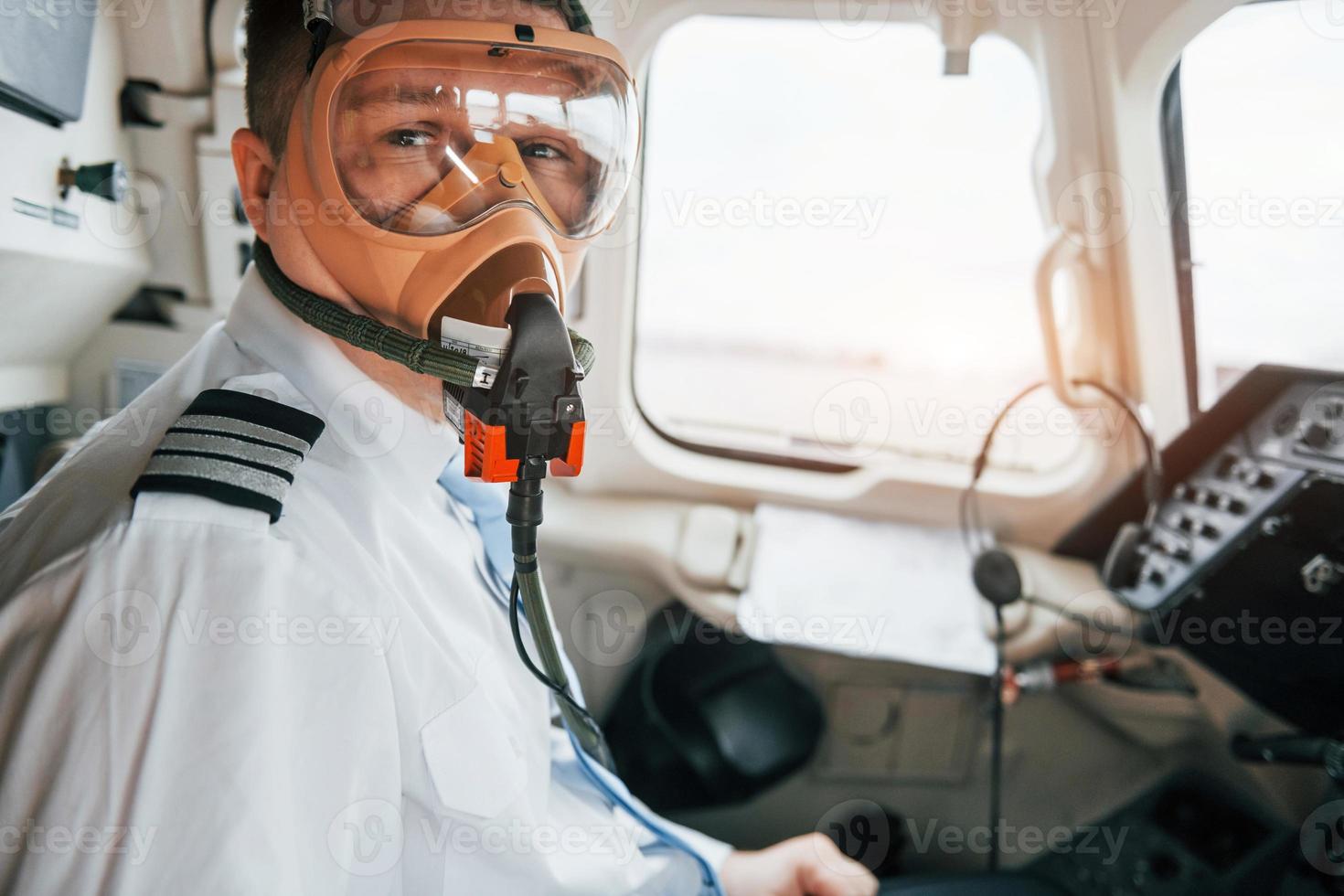 in zuurstof masker. piloot Aan de werk in de passagier vliegtuig. voorbereidingen treffen voor uittrekken foto