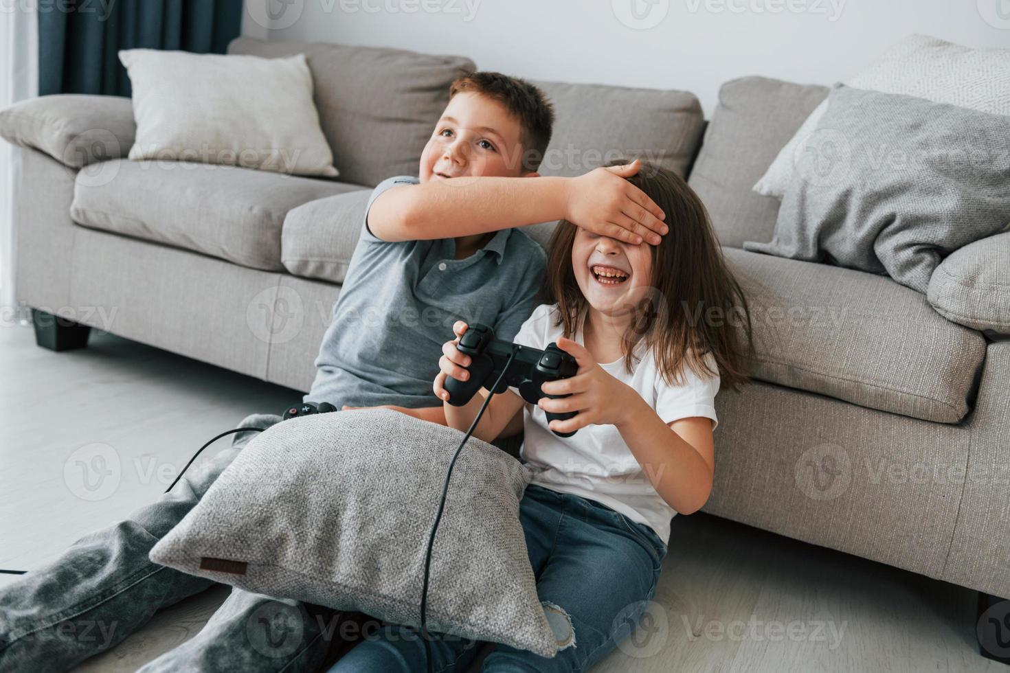 spelen videospellen. kinderen hebben pret in de huiselijk kamer Bij dag samen foto