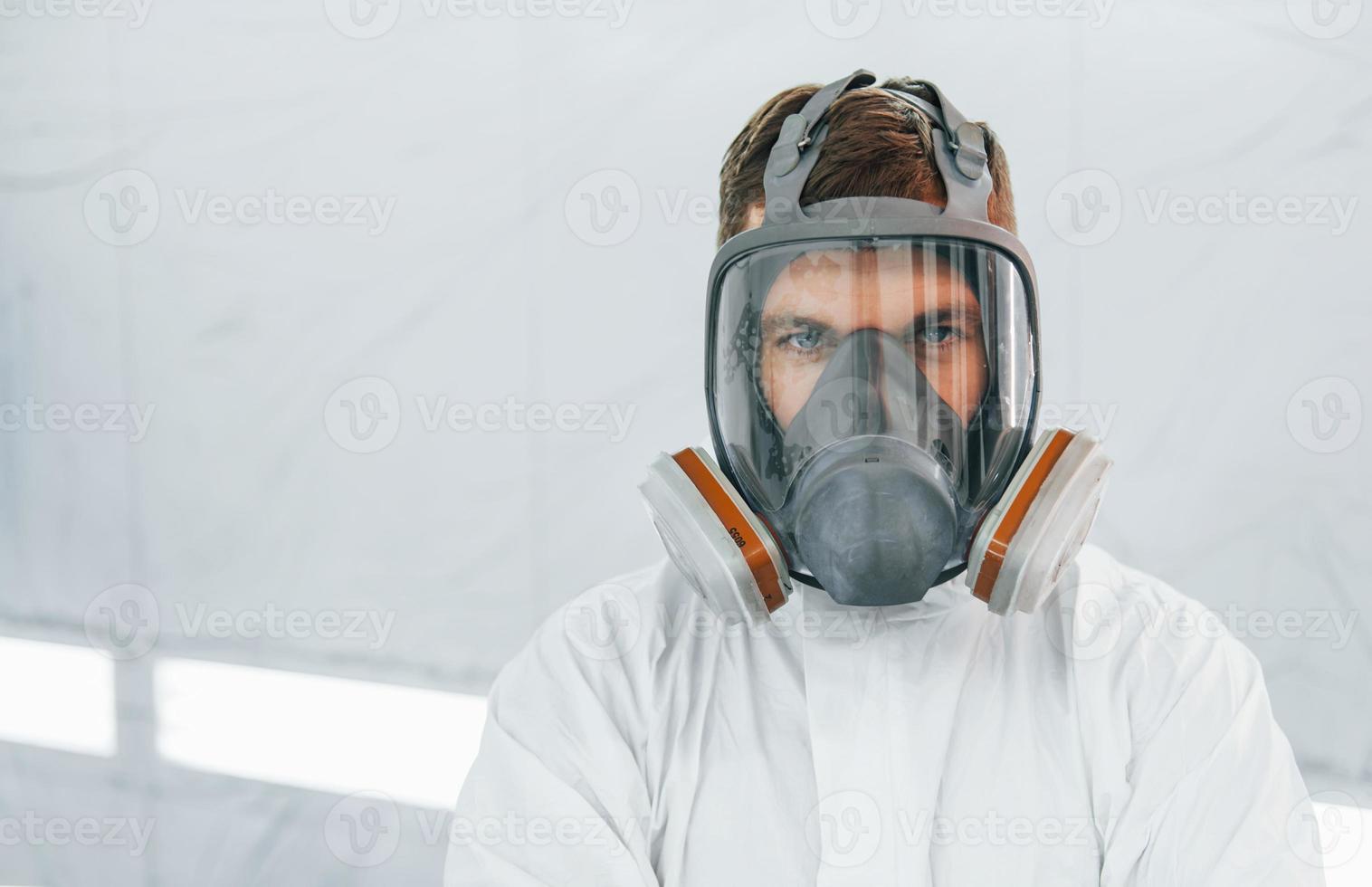 portret van Mens in de beschermend masker. arbeider in uniform is in de auto onderhoud foto