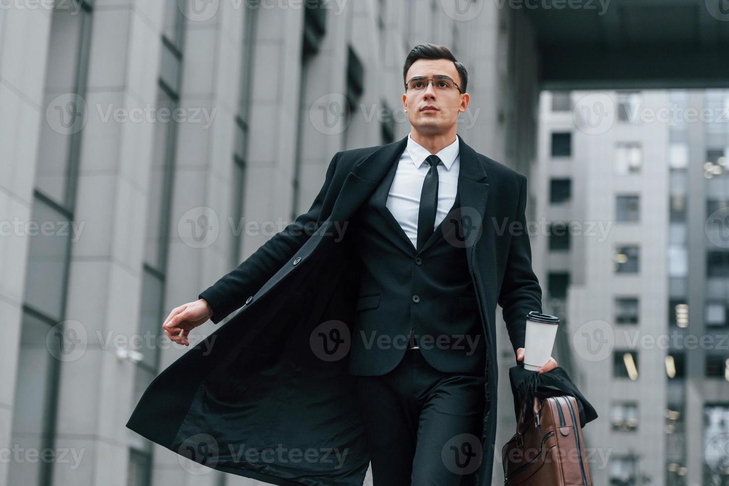 wandelen naar voren. zakenman in zwart pak en stropdas is buitenshuis in de stad foto