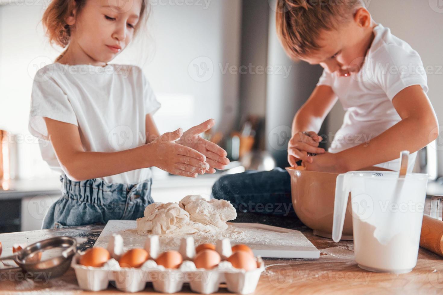 maken snoepgoed. weinig jongen en meisje voorbereidingen treffen Kerstmis koekjes Aan de keuken foto