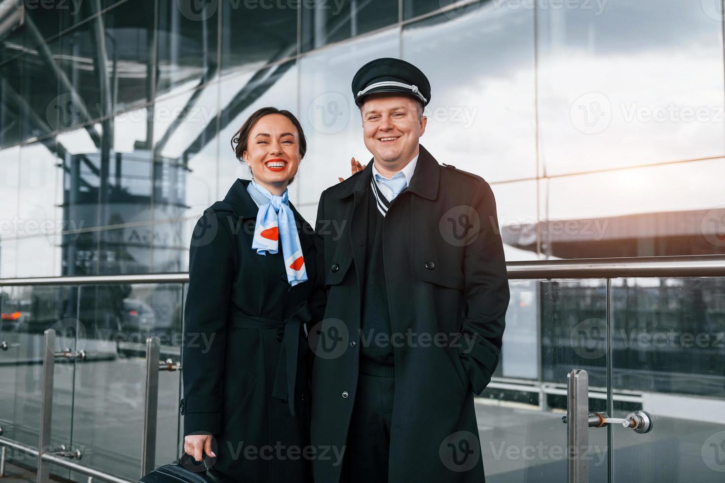 Mens met vrouw. vliegtuig bemanning in werk uniform is samen buitenshuis in de luchthaven foto