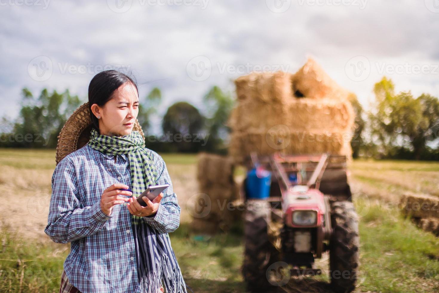 vrouw boer gebruik makend van technologie mobiel in rijst- veld- foto