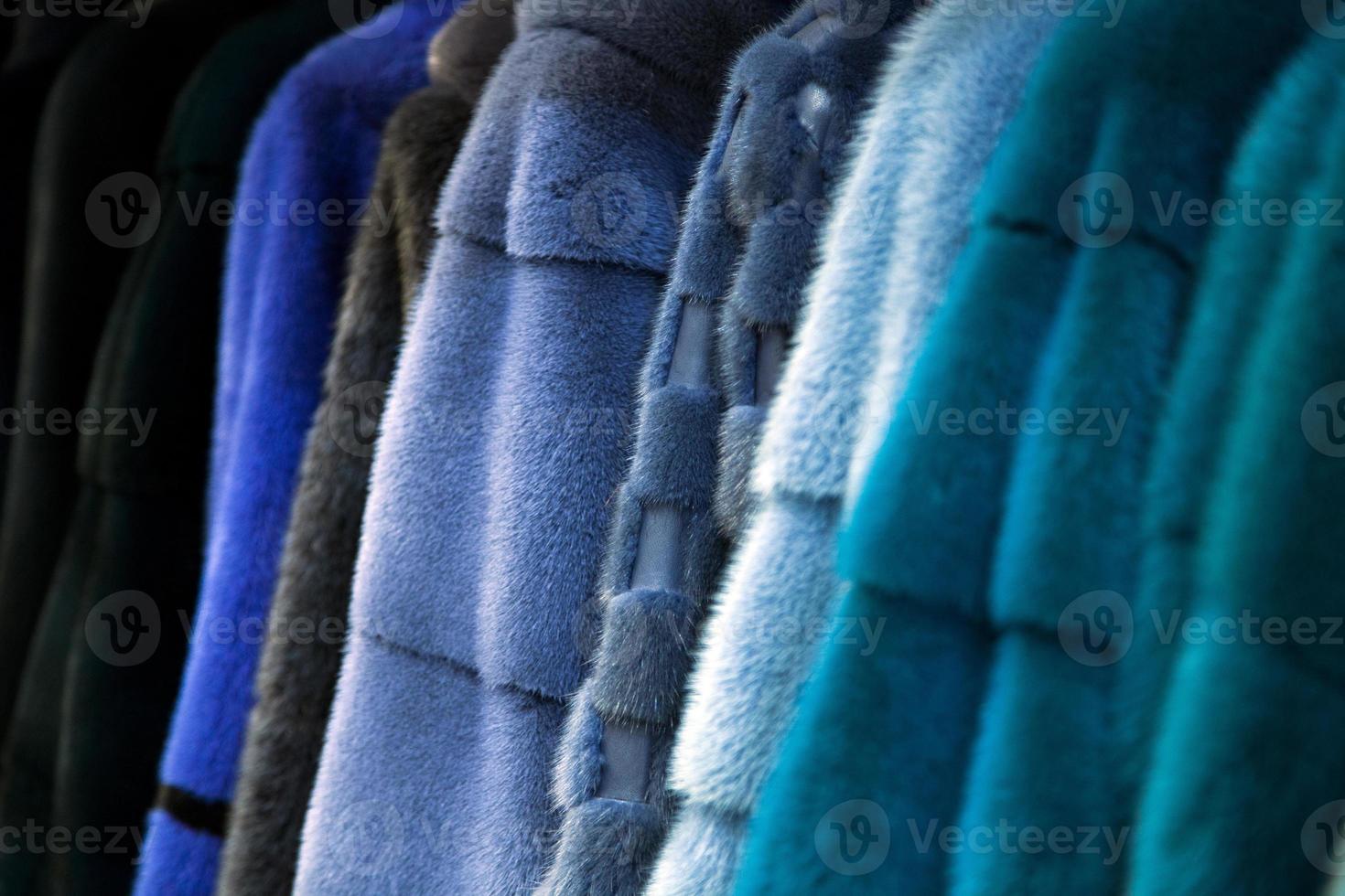 een dichtbij omhoog van een vacht jas van natuurlijk nerts vacht van verschillend kleuren grijs, blauw, groen en zwart hangende in een rij in de op te slaan foto