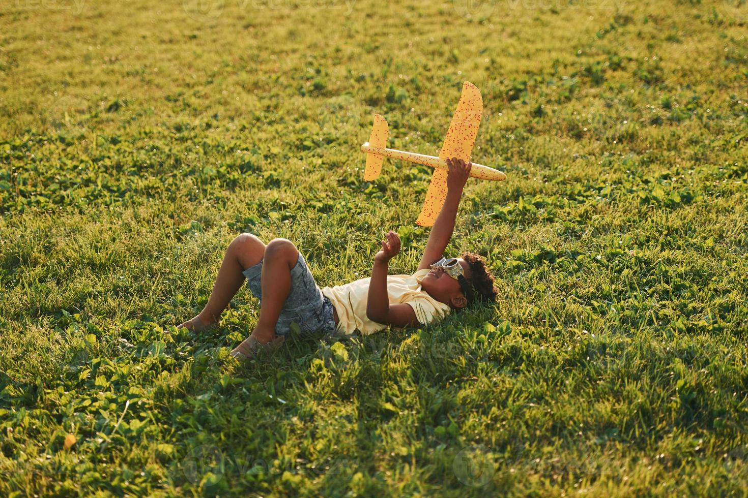 mooi zomer dag. Afrikaanse Amerikaans kind hebben pret Aan de veld- foto