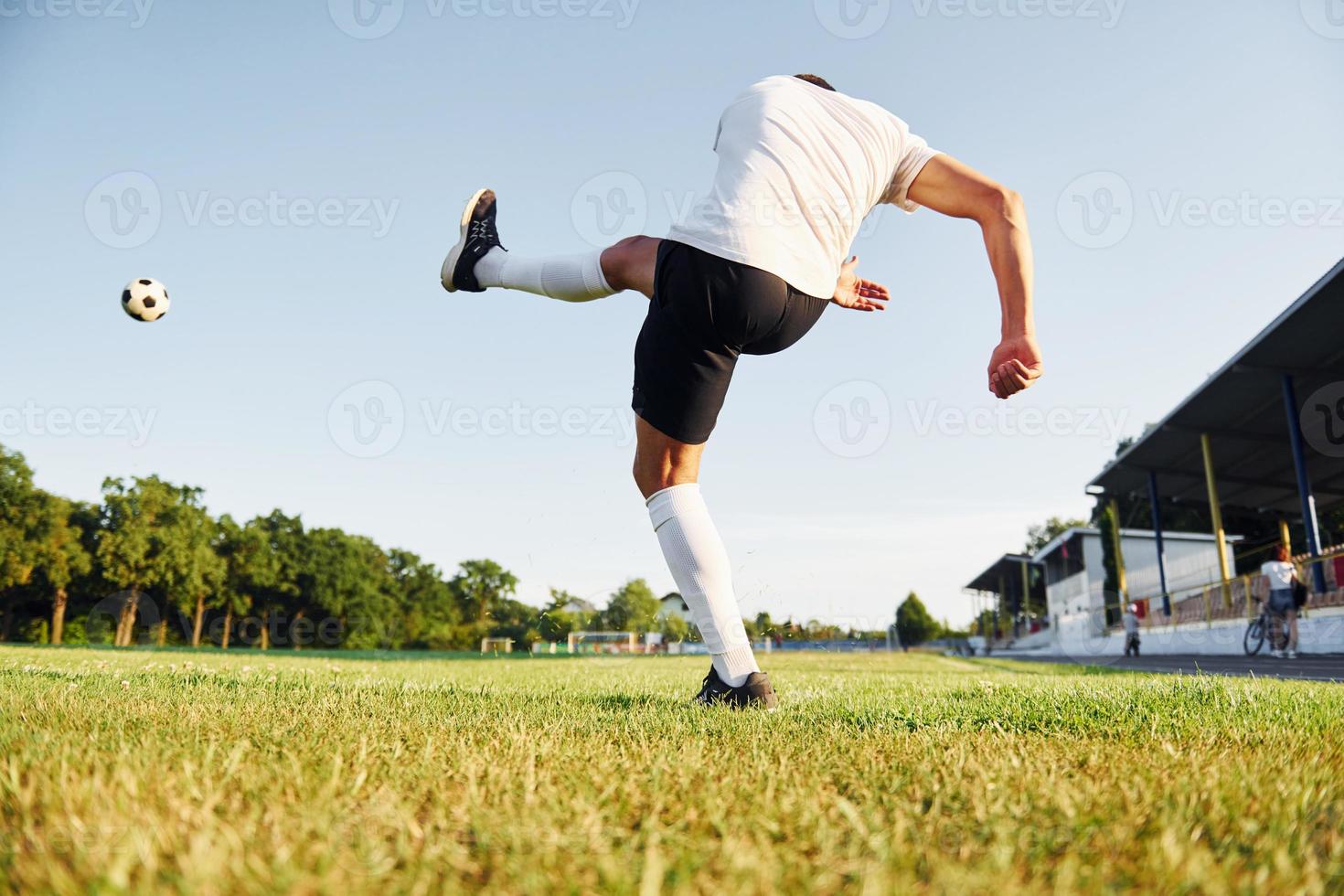 schopt de bal. jong voetbal speler hebben opleiding Aan de sportief veld- foto