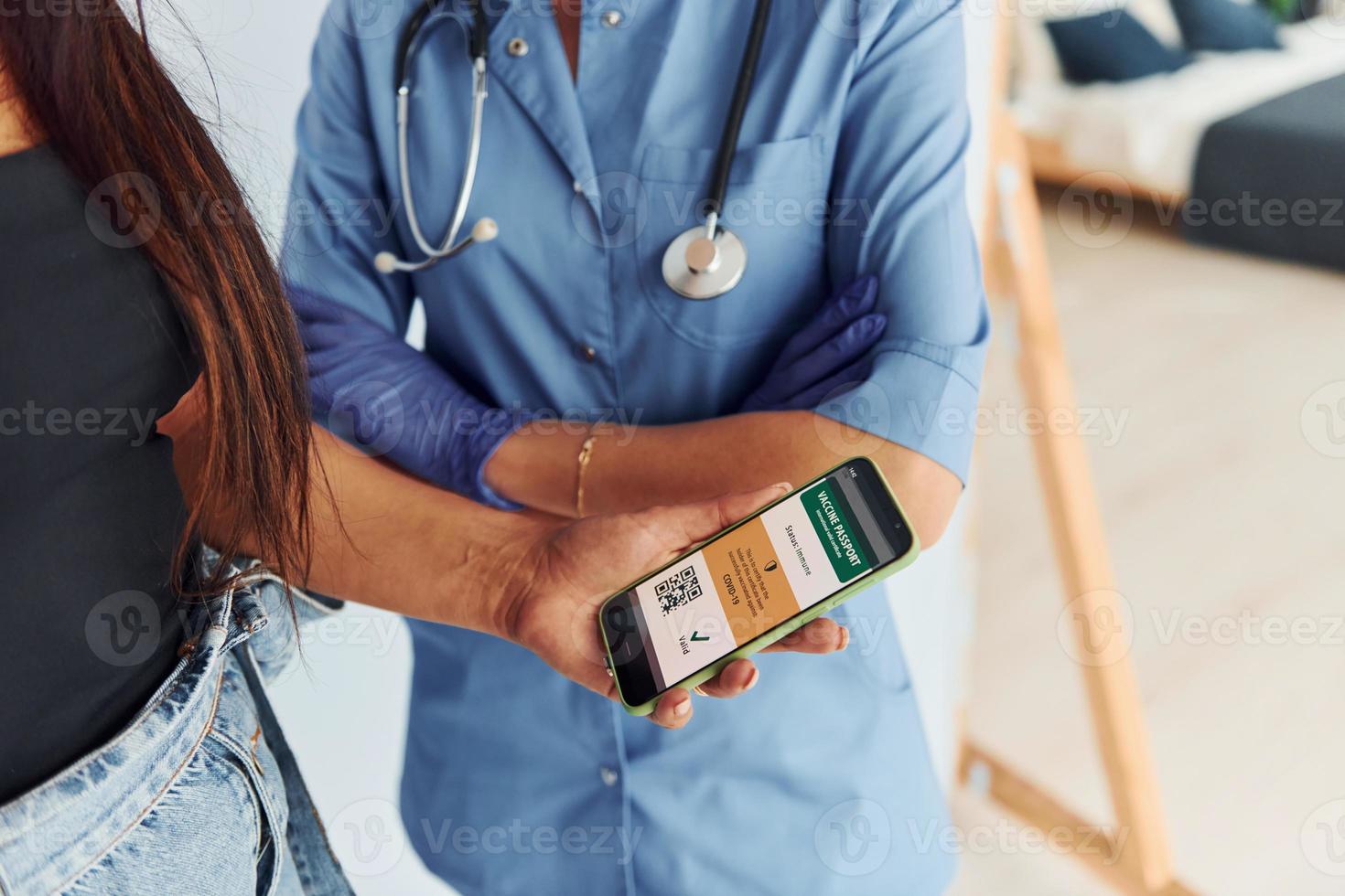 met digitaal paspoort. dokter in uniform maken vaccinatie naar de geduldig foto