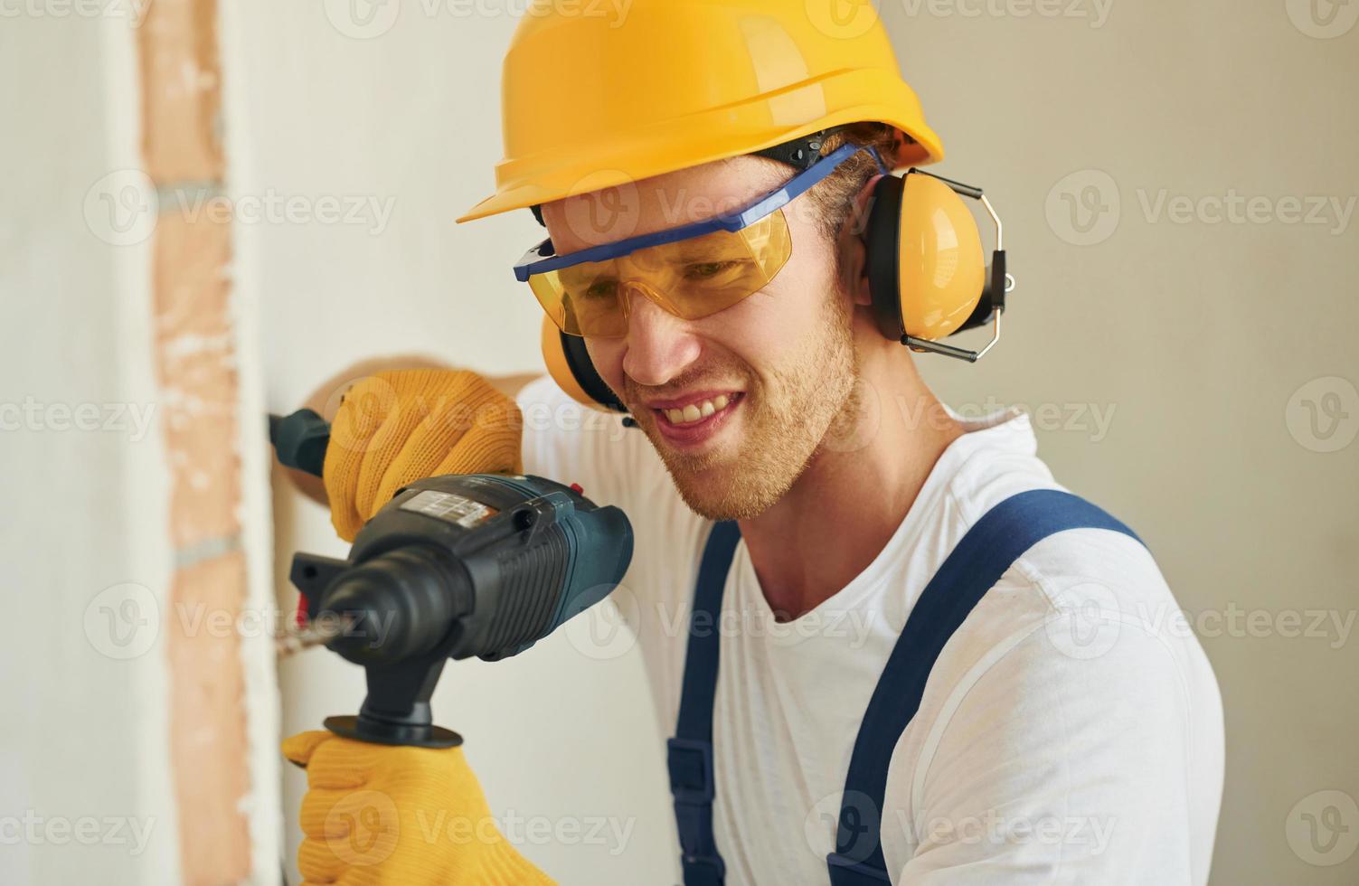 portret van jong Mens werken in uniform Bij bouw Bij dag foto