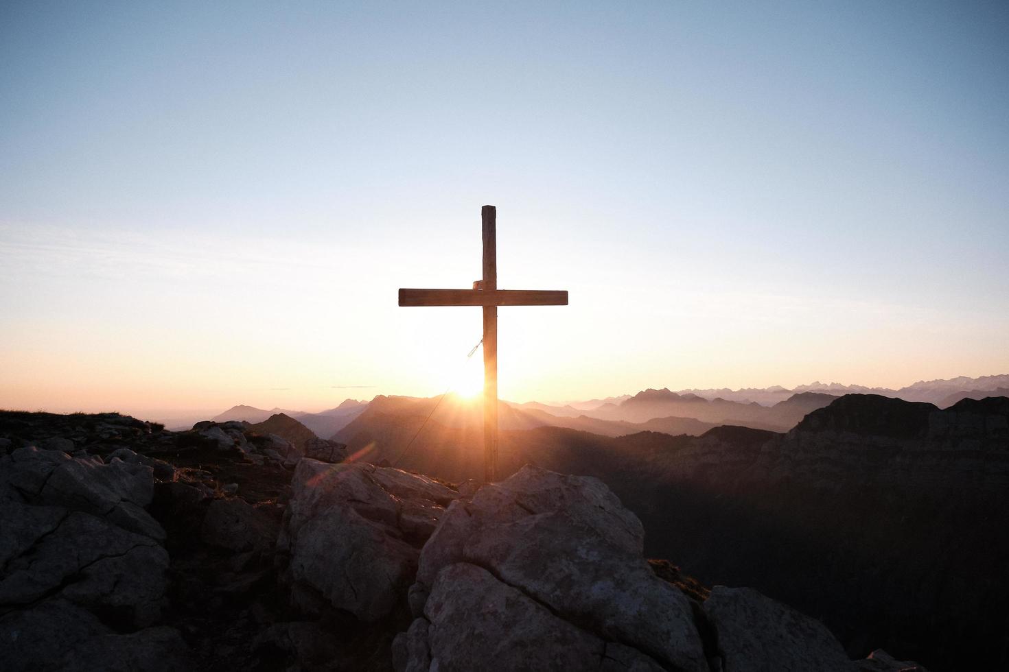 kruis op een berg bij zonsondergang foto