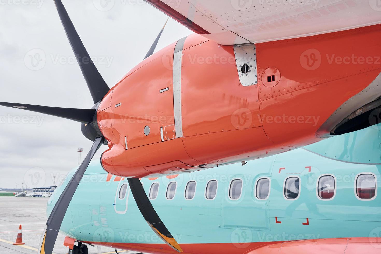 oranje en blauw gekleurd. turboprop vliegtuig geparkeerd Aan de landingsbaan Bij dag foto