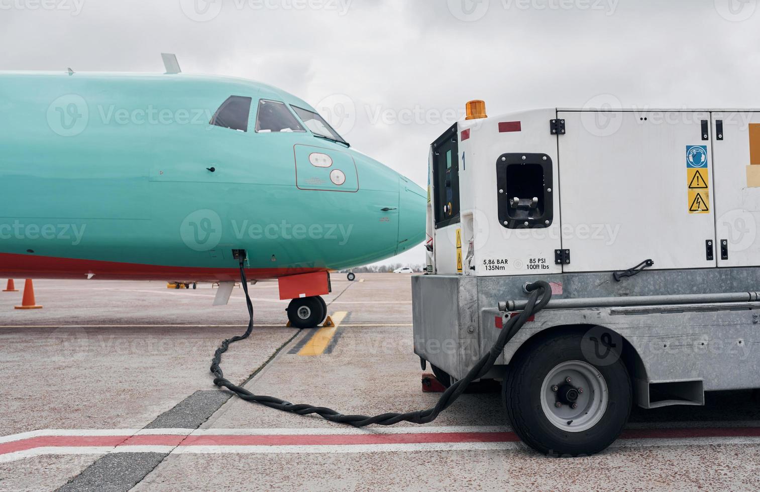 voertuig in de buurt. turboprop vliegtuig geparkeerd Aan de landingsbaan Bij dag foto