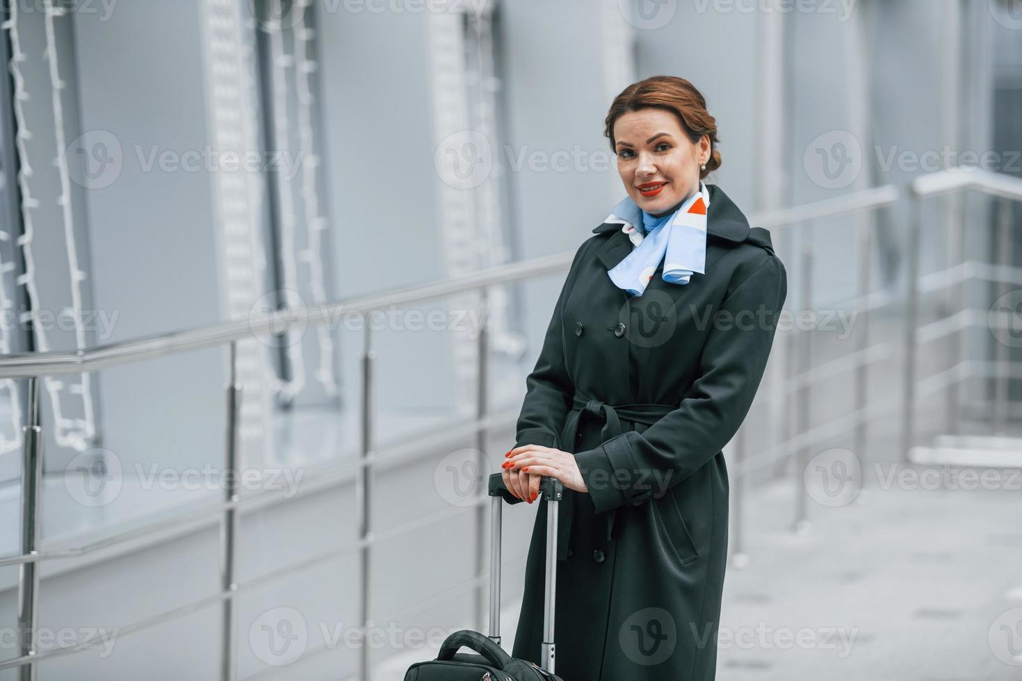 vrouw passagier met bagage is buitenshuis in de buurt luchthaven foto