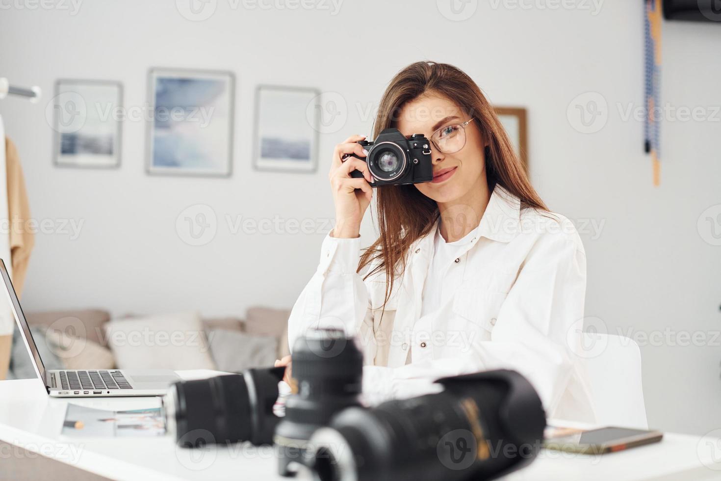 vrouw fotograaf in gewoontjes kleren is werken binnenshuis Bij dag foto