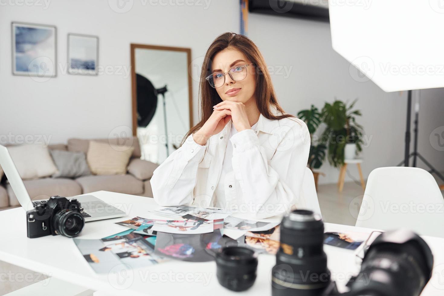 vrouw fotograaf in gewoontjes kleren is werken binnenshuis Bij dag foto