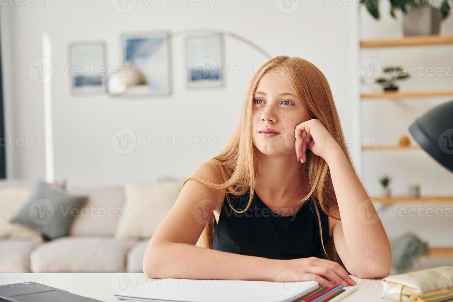 leunend Aan de tafel. vrouw tiener met blond haar- is Bij huis Bij dag foto