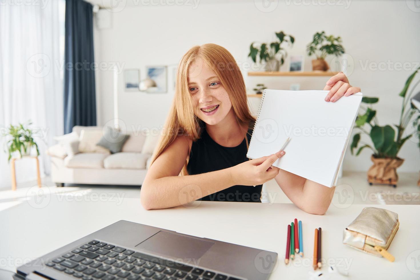 online school. vrouw tiener met blond haar- is Bij huis Bij dag foto