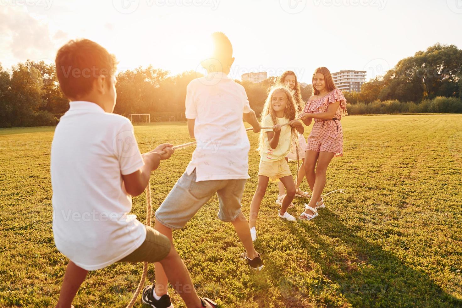 hebben plezier. groep van gelukkig kinderen is buitenshuis Aan de sportief veld- Bij dag foto