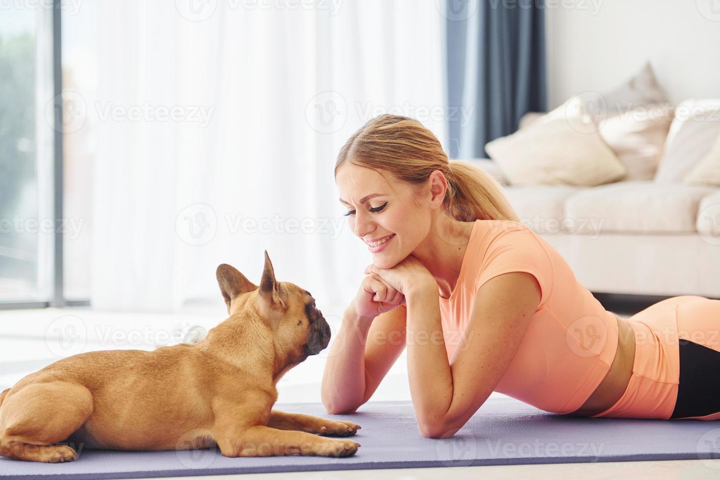 houdende naar beneden Aan de mat. vrouw met mopshond hond is Bij huis Bij dag foto