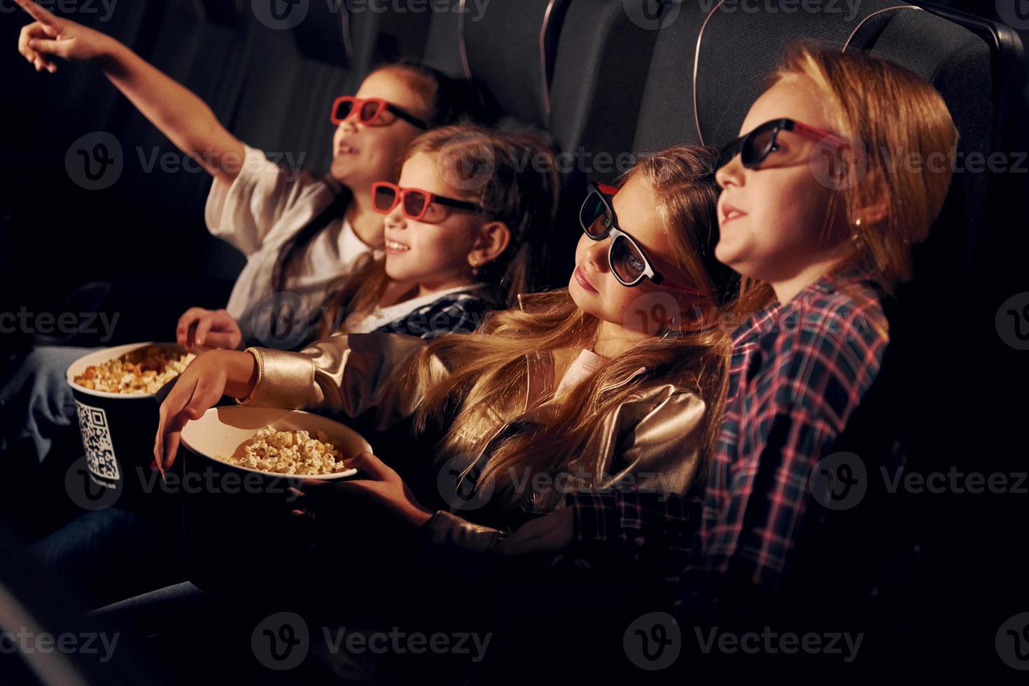 in 3d bril. groep van kinderen zittend in bioscoop en aan het kijken film samen foto