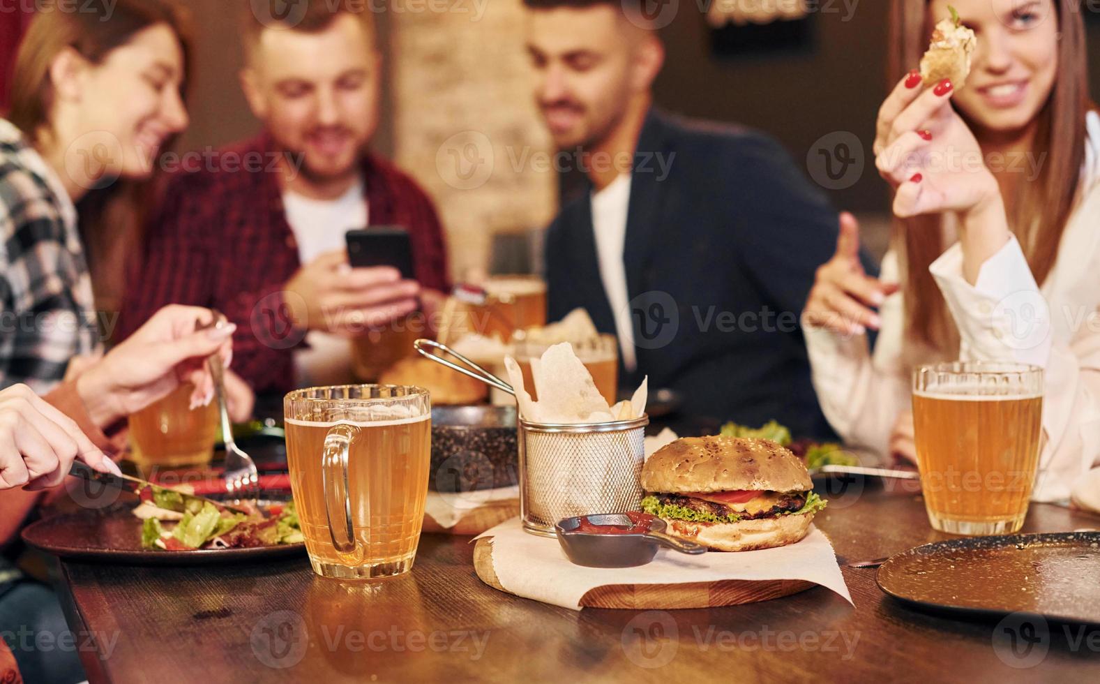 weekend vrije tijd. groep van jong vrienden zittend samen in bar met bier foto