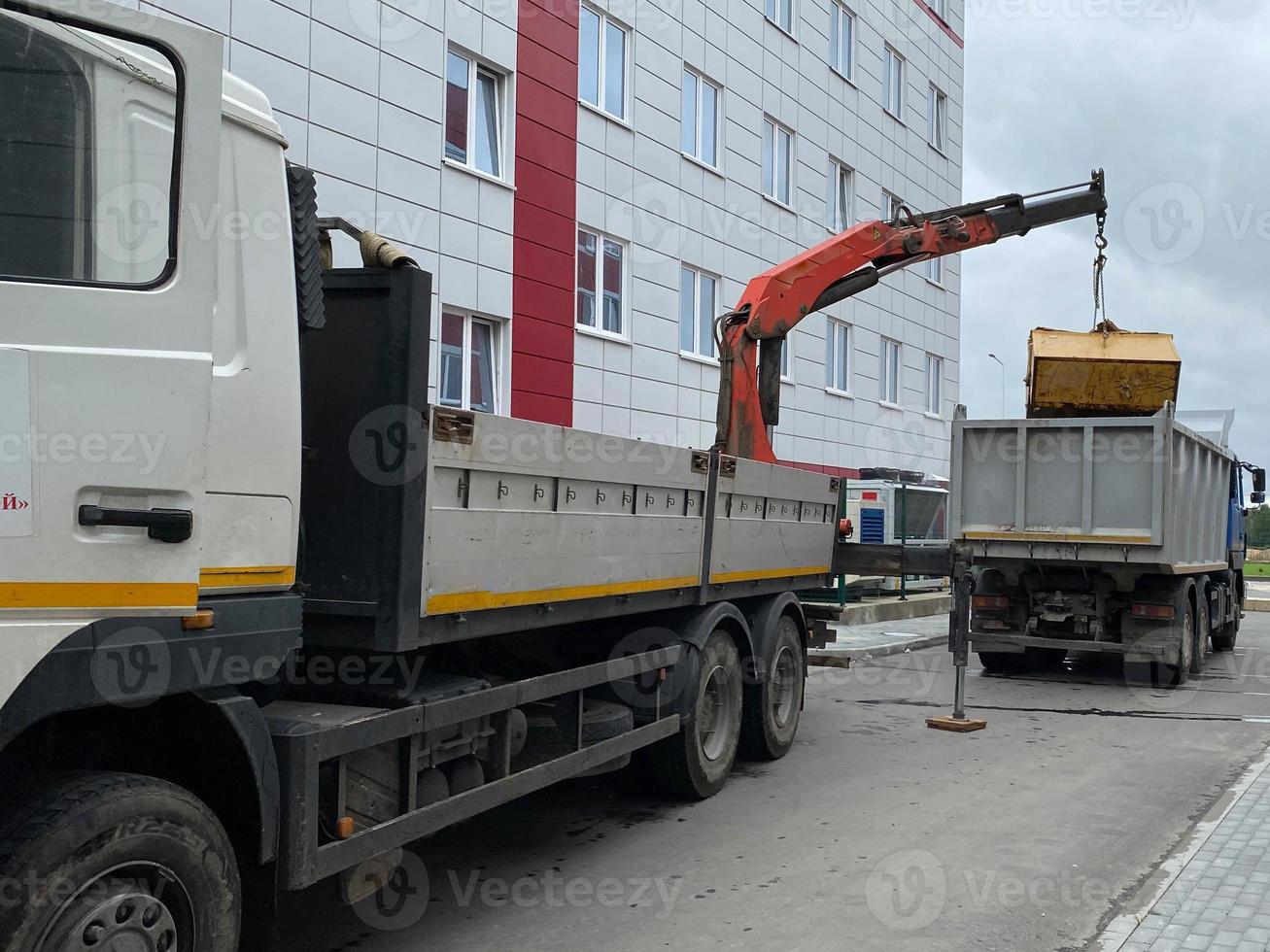 een groot, krachtig vuilnis vrachtauto lost vuilnis met een manipulator voor volgend recycling van middelen foto